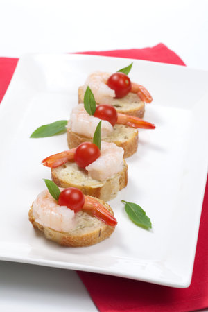 Closeup of delicious Shrimp Canape with cherry tomatoes, basil and wasabi spread.の写真素材