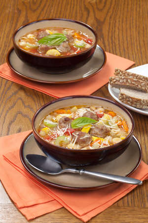 Two bowls of hot fresh  Italian Meatball Soup and wholegrain breadの写真素材