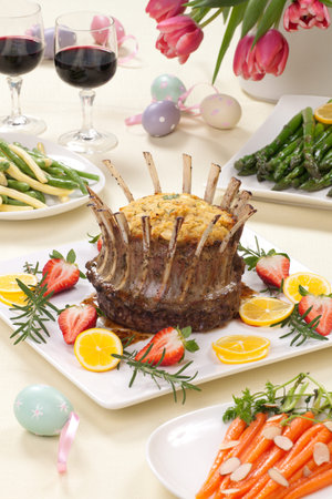 Crown roast of lamb with apple rosemary stuffing. Garnished with fresh strawberry, lemon, and...
