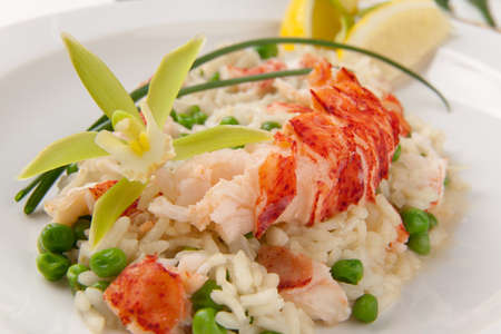 Lobster and green pea Risotto garnished with chives, lemon, and orchid flower の写真素材
