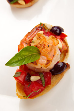 Closeup of delicious Olive - Tomato Bruschetta with garlic shrimp and pine nuts の写真素材