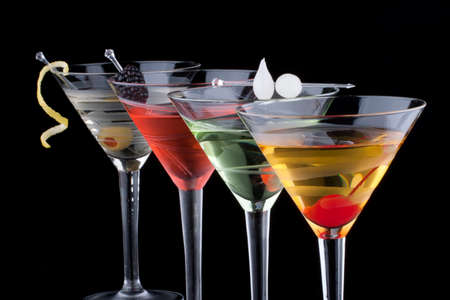 Classical martini in chilled glass over black background on reflection surface, garnished , maraschino cherry, marinated pearl onoions, olive and lemon twist  Most popular cocktails series の写真素材