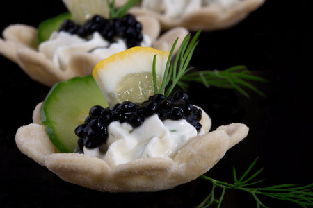 Closeup of black caviar on Creme Fraiche over black background の写真素材