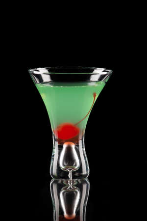 Appletini cocktail in contemporary martini glass over black background garnished with maraschino cherry  Most popular cocktails series の写真素材