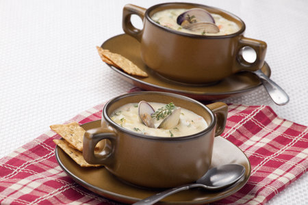 Bowls of hot delicious clam chowder garnished with fresh thyme, and multy grain crackersの写真素材
