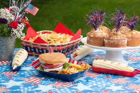Cornbread, corn and burgers on 4th of July picnic in patriotic themeの写真素材