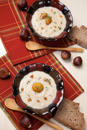 Closeup of bowls of hot chestnut kohlrabi soup with thyme and caramelized chestnut の写真素材