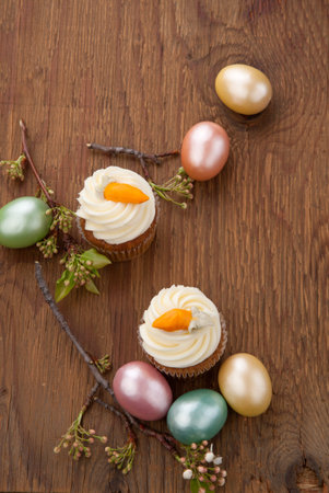 Two carrot cake muffins, Easter eggs, and spring blooming twigs 
