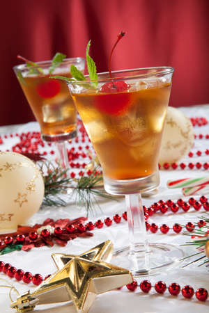 Glasses of Mint Manhattan cocktails surrounded with Christmas ornaments and decorations. Holiday cocktails series.の写真素材
