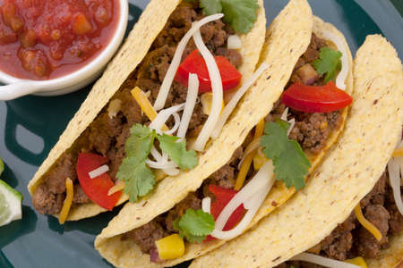 Assorted Mexican dishes, with whole grain corn beef tacos as the main subject.の写真素材