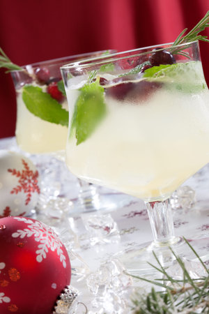 Close-up of white cranberry spritzer cocktail on holiday table with Christmas ornaments. Holiday cocktails series.の写真素材