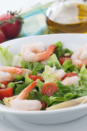 Plate of Italian shrimp salad with shrimp, tomatoes, artishocke hearts, Romane lettuce leaves, fava beans, and pine nuts. Olive oil.の写真素材