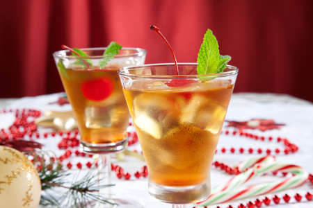 Glasses of Mint Manhattan cocktails surrounded with Christmas ornaments and decorations. Holiday cocktails series.の写真素材