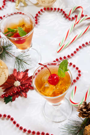 Glasses of Mint Manhattan cocktails surrounded with Christmas ornaments and decorations. Holiday cocktails series.の写真素材