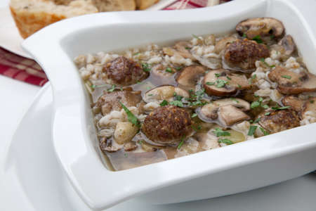 Hot delicious Mushroom Barley Soup with Mini Meatballs and cheese bread.の写真素材