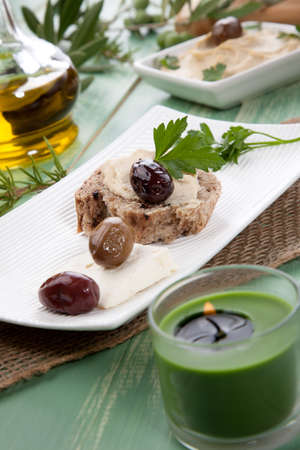 Appetizer plate with whole grain bread with hummus, feta cheese, olives, and parsley.の写真素材
