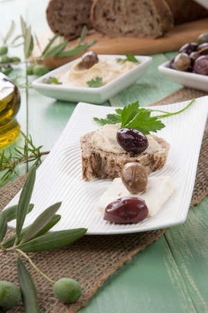 Appetizer plate with whole grain bread with hummus feta cheese olives and parsley.の写真素材