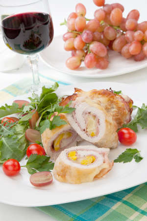 Tasty chicken prosciutto roulade stuffed with cheese and pineapple served with baby kale grapes and cherry tomatoes salad.の写真素材