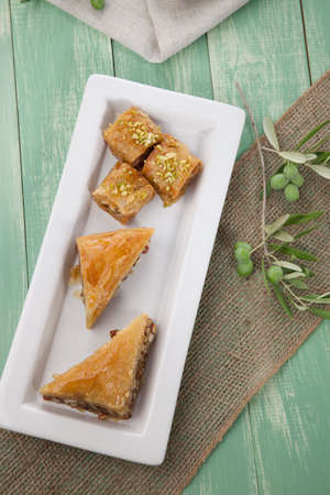 Mediterranean traditional pastries  Baklava  served with Greek style black olives on a wooden tableの写真素材