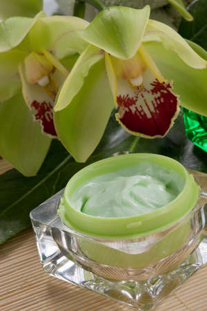 Closeup of two jars of cosmetics cream and blooming Cymbidium orchid flowers for everyday use.の写真素材
