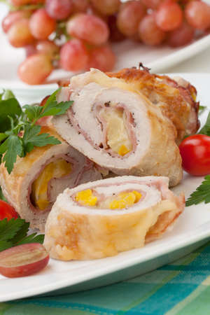 Tasty chicken prosciutto roulade stuffed with cheese and pineapple served with baby kale grapes and cherry tomatoes salad.の写真素材