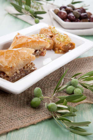 Mediterranean traditional pastries  Baklava  served with Greek style black olives on a wooden tableの写真素材