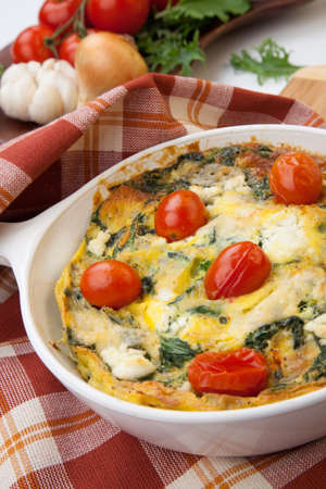 Closeup of pan with fresh made frittata with baby kale sundried tomatoes and goat cheese.の写真素材