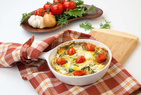 Closeup of pan with fresh made frittata with baby kale sundried tomatoes and goat cheese.の写真素材