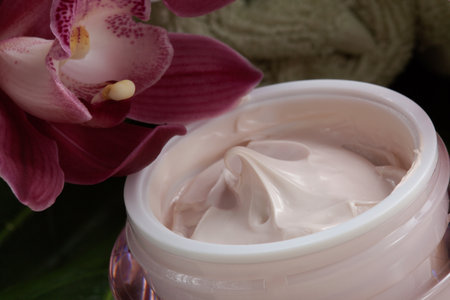 Dark pink blooming Cymbidium orchid flowers and moisturizing face cream for everyday.の写真素材
