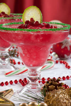 Two frozen pomegranate margaritas cocktails on Christmas decorated holiday table with Christmas ornaments. Holiday cocktails series.の写真素材
