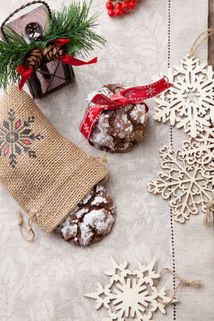 Closeup of melty Chocolate - Truffle cookies on holiday table. Christmas ornaments, decorations, and red berries.の写真素材