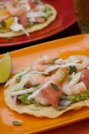 Two plates of shrimp ceviche tostadas with fennel and grapefruit, beer, garnished with mini bell pepper.の写真素材