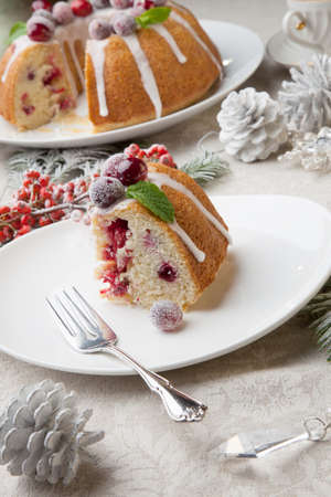 Piece of traditional Christmas cranberry cake decorated with Christmas ornaments.の写真素材