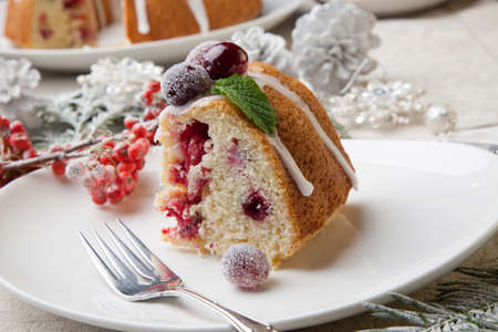 Piece of traditional Christmas cranberry cake decorated with Christmas ornaments.の写真素材