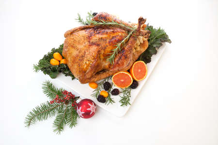 Roasted stuffed turkey garnished with fresh fruits and herbs for holiday dinner.の写真素材