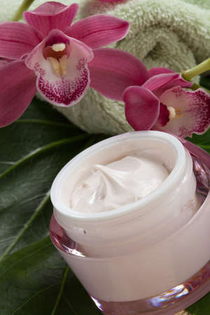Dark pink blooming Cymbidium orchid flowers and moisturizing face cream for everyday.の写真素材