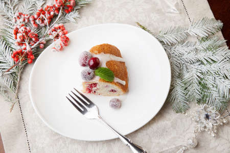 Piece of traditional Christmas cranberry cake decorated with Christmas ornaments.の写真素材
