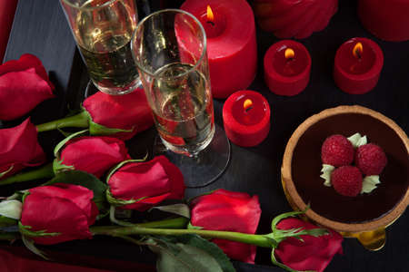 Celebration tray for Valentines Day - Champagne, chocolate raspberry cake, candles, and red roses.の写真素材