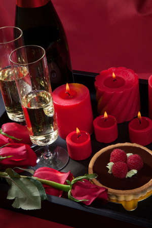 Celebration tray for Valentines Day - Champagne, chocolate raspberry cake, candles, and red roses.の写真素材