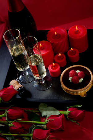 Celebration tray for Valentines Day - Champagne, chocolate raspberry cake, candles, and red roses.の写真素材