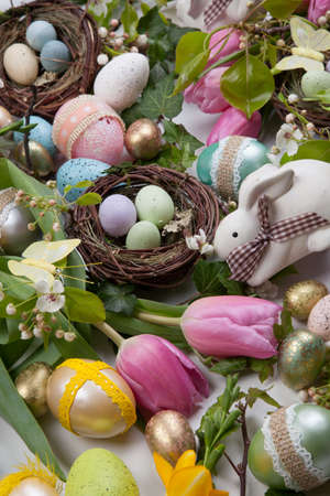 Close up of Easter assortiment of Easter eggs, spring flowers, and toys over white backgroundの写真素材