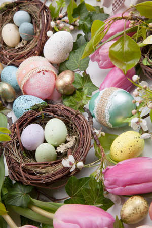 Close up of Easter assortiment of Easter eggs, spring flowers, and toys over white backgroundの写真素材