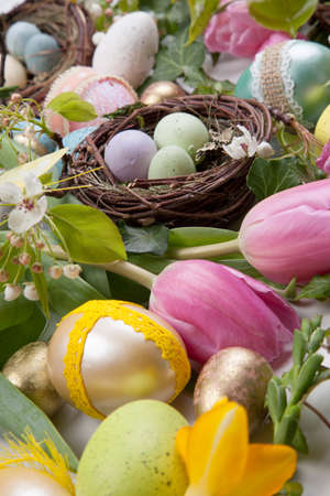 Close up of Easter assortiment of Easter eggs, spring flowers, and toys over white backgroundの写真素材