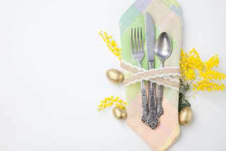 Easter table set with eggs and mimosa flowers isolated on white background.の写真素材