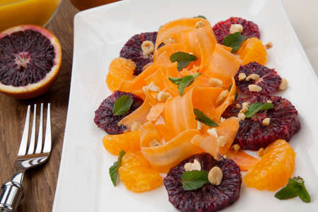 Closeup of a plate of blood oranges, carrots, and tangerines salad with peanut-mint dressing.の写真素材