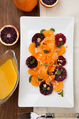 Closeup of a plate of blood oranges, carrots, and tangerines salad with peanut-mint dressing.の写真素材