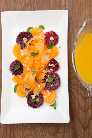 Closeup of a plate of blood oranges, carrots, and tangerines salad with peanut-mint dressing.の写真素材
