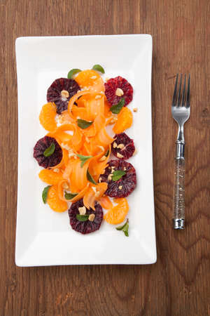 Closeup of a plate of blood oranges, carrots, and tangerines salad with peanut-mint dressing.の写真素材