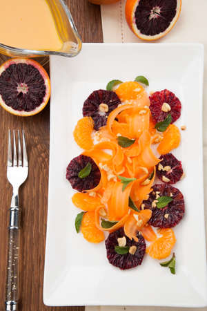 Closeup of a plate of blood oranges, carrots, and tangerines salad with peanut-mint dressing.の写真素材