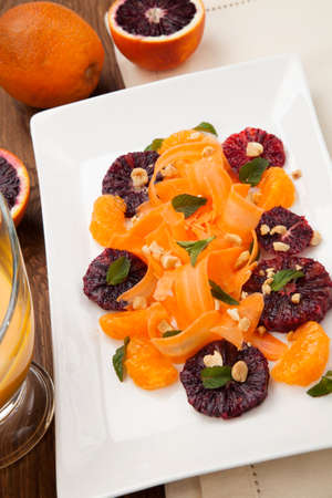 Closeup of a plate of blood oranges, carrots, and tangerines salad with peanut-mint dressing.の写真素材